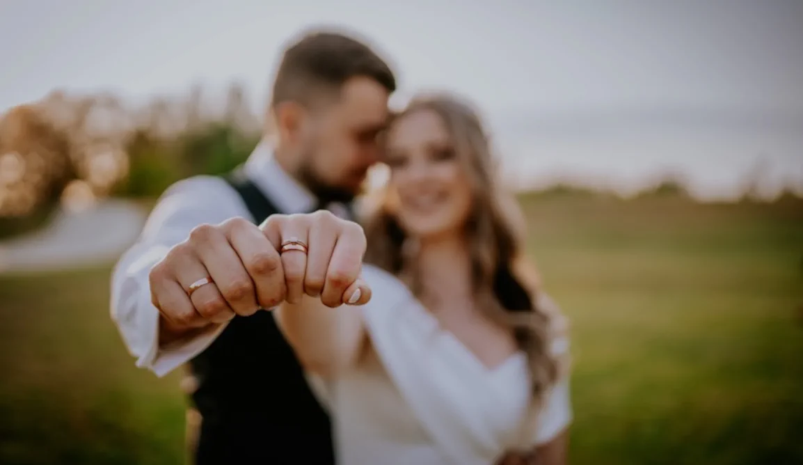 Newlywed couple showing off wedding rings